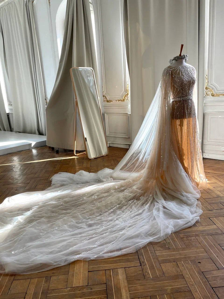 Custom wedding dress with extra long train — beaded cape gown on mannequin in Paris-style atelier